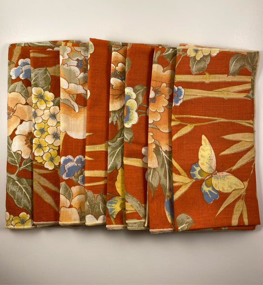 Orange napkins with butterflies, birds and flowers.  Set of 8